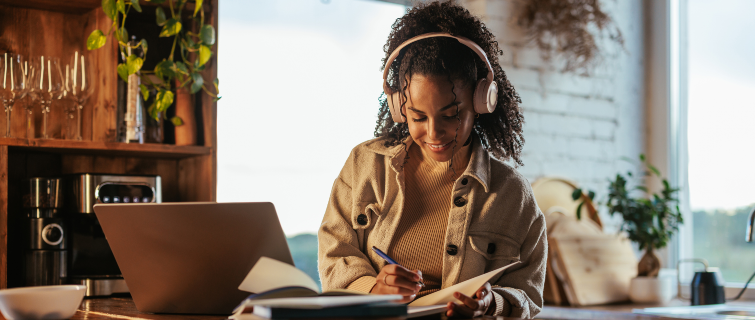 A young female student is at home studying at her laptop.