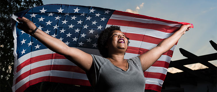 Woman holding American flag in the air.
