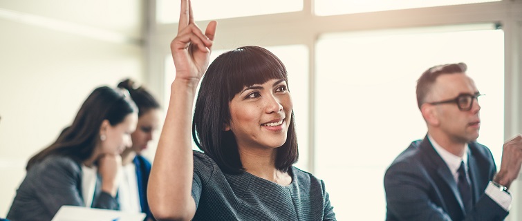 Woman raising her hand in class.