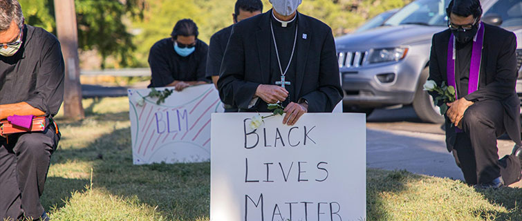 Religious leaders kneeling during peaceful protest.