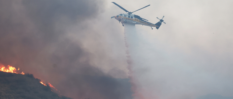 Helicopter drops water over the Hughes Fire