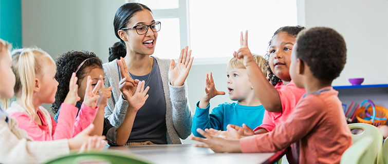 Teacher working with a group of toddlers.