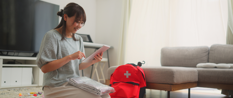 A woman is preparing an emergency bag in the living room at home.