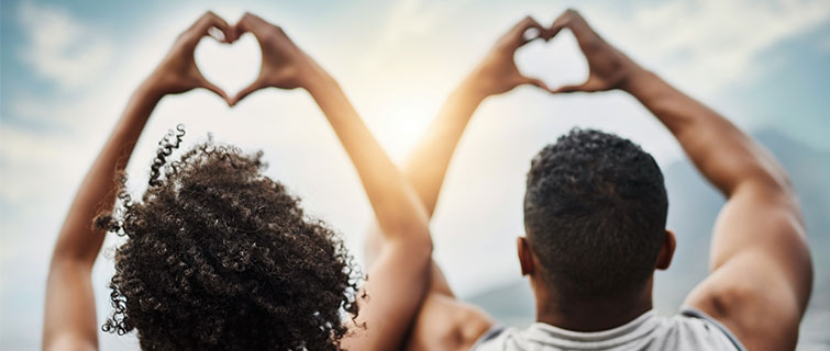 Two athletes making a heart shape with their hands.