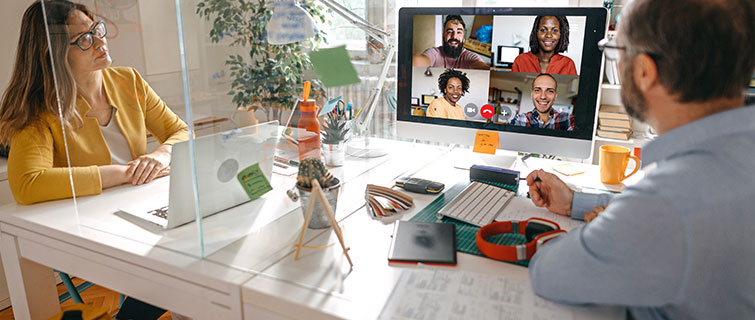 Two business people in office on a video conference call.