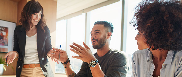 Three business people talking in an office.