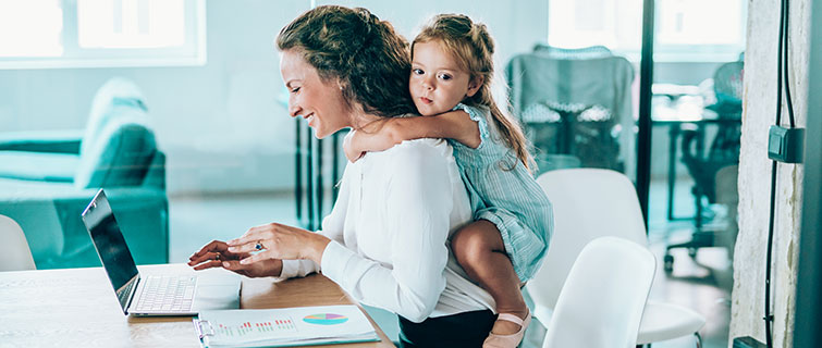 Working mother with daughter during an online meeting.