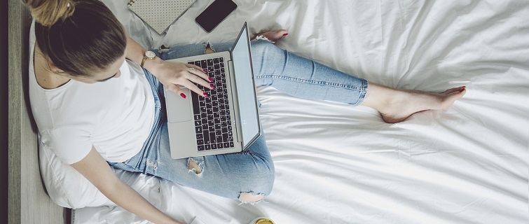 Woman using laptop in bed