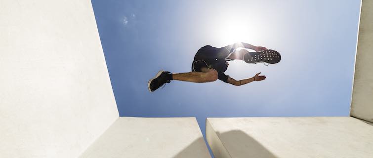 Person doing parkour leaping over chasm