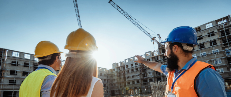 Engineer showing building activity on the construction site with cranes