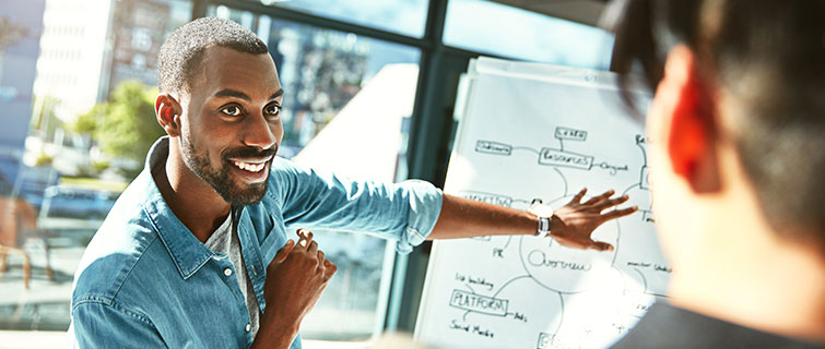 Man presenting a course idea on a whiteboard.