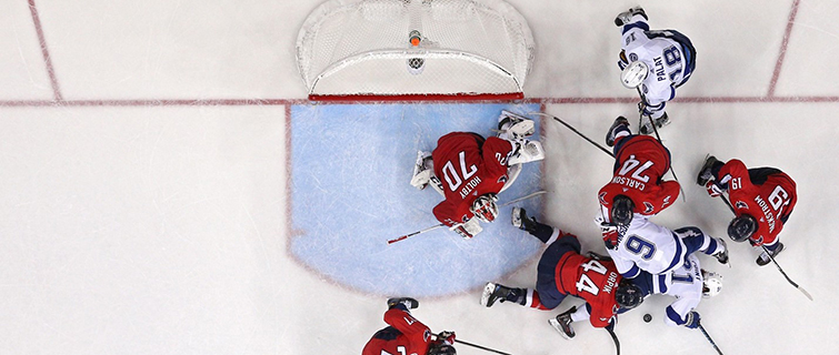 Caps and Lightning players battle for a puck in front of the Capitals net