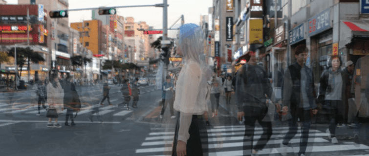 Person standing at a crowded crosswalk