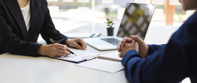 Person reviewing document with another person