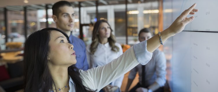 business people having discussion at whiteboard