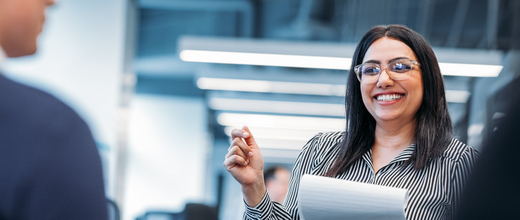 Indian woman speaking with colleagues in office meeting