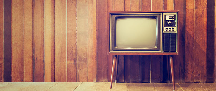 An old television sits in a paneled living room