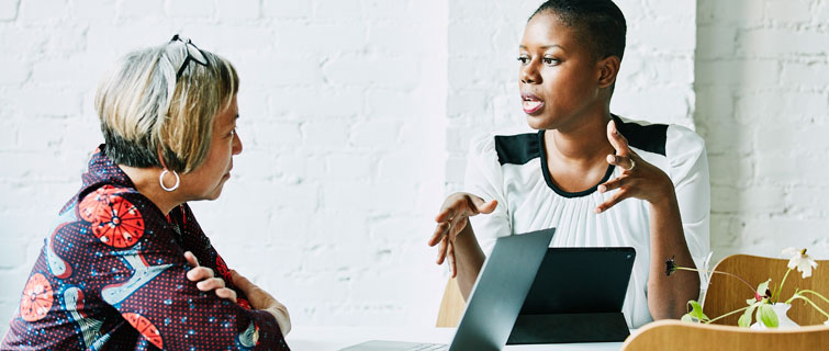 Women negotiating in conference room.