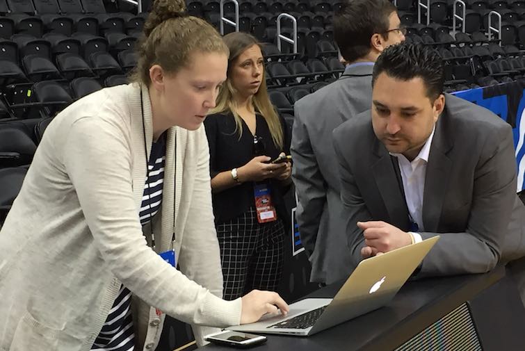 Erin Cummings (left) works courtside on preparations for the championship game.